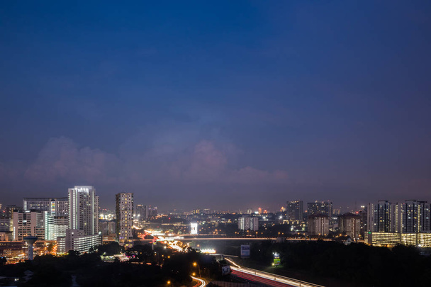 Weergave van moderne stad tijdens het blauwe uur met lichte trail - Foto, afbeelding