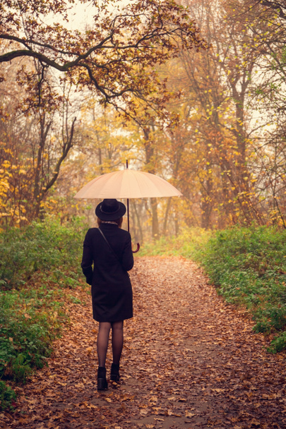 vrouw lopen onder een paraplu - Foto, afbeelding