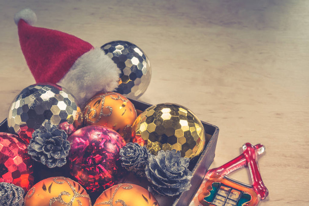 Merry Christmas concept - baubles in box, little glassy house and Santa Claus hat - 写真・画像
