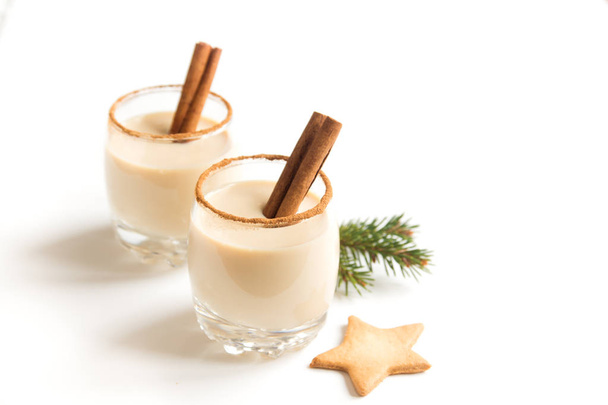 Eggnog with cinnamon and nutmeg for Christmas and winter holidays. Christmas Eggnog, gingerbread cookies isolated on white background. - Foto, Imagen