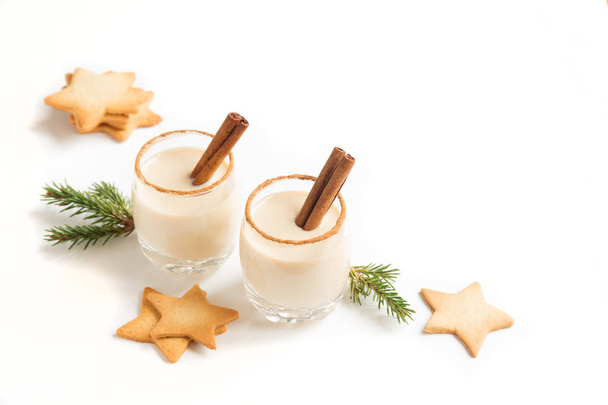 Eggnog with cinnamon and nutmeg for Christmas and winter holidays. Christmas Eggnog, gingerbread cookies isolated on white background. - Фото, зображення