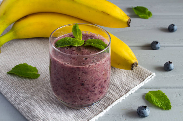Smoothie from banana and blueberries on the grey napkin - Photo, Image