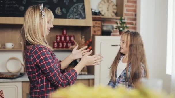 Charming mom and daughter have fun in a cosy kitchen. - Video, Çekim
