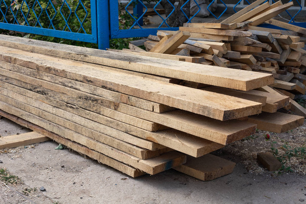Πεύκο ξύλο ξυλεία στοίβα των φυσικών ακατέργαστων ξύλινες σανίδες στο εργοτάξιο. Βιομηχανικής ξυλείας, οικοδομικών υλικών για ξυλουργικές εργασίες, κατασκευή, επισκευή και έπιπλα, ξυλείας για στέγες κατασκευές. - Φωτογραφία, εικόνα