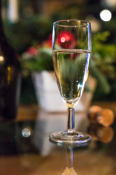Наполненный бокал вина в рождественском украшении с размытым фоном
 - Фото, изображение