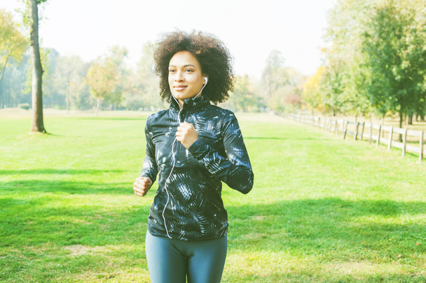 Здорові діяльність в парку, фітнес африканською жінкою, біг на зелені поля в природі  - Фото, зображення