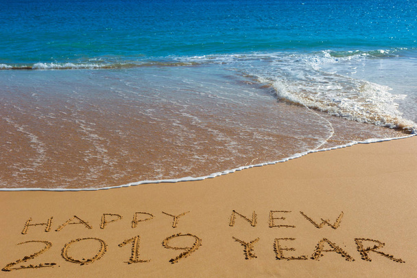 HAPPY NEW 2019 YEAR inscription written in the wet yellow beach sand. Concept of celebrating the New Year. - Photo, Image
