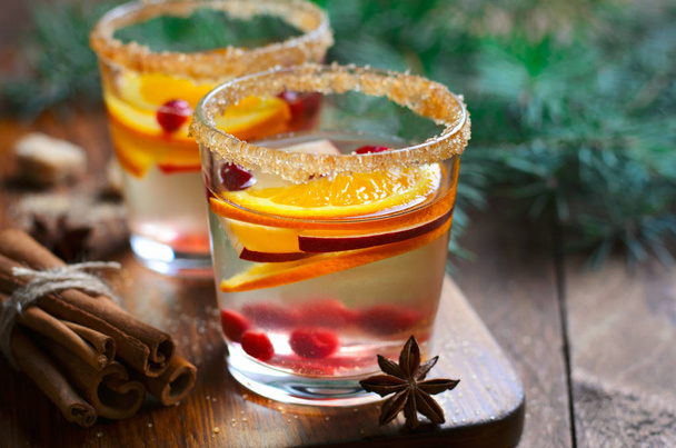 Winter Cocktail, Christmas Sangria with Apple Slices, Orange, Cranberry and Cinnamon, Refreshing Drink on Wooden Background - Photo, Image