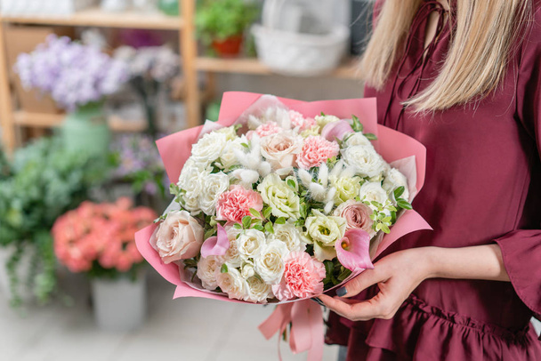 Europese bloemen winkel. Twee boeket van mooie gemengde bloemen in de hand van de vrouw. Uitstekende tuin bloemen in de rangschikking, het werk van een professionele bloemist. - Foto, afbeelding