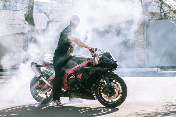 Burnout on stunt motorcycle with bright sun on background - Photo, Image
