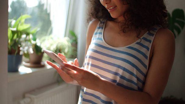 Young woman texting on mobile phone at home. - Foto, Imagen