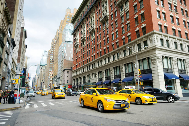 NEW YORK - MARCH 16, 2015: Yellow taxi cabs and people rushing on busy streets of downtown Manhattan - Foto, Imagen