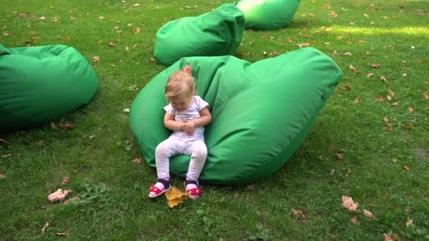Маленькая девочка играет на бобовых мешках в природе
 - Кадры, видео