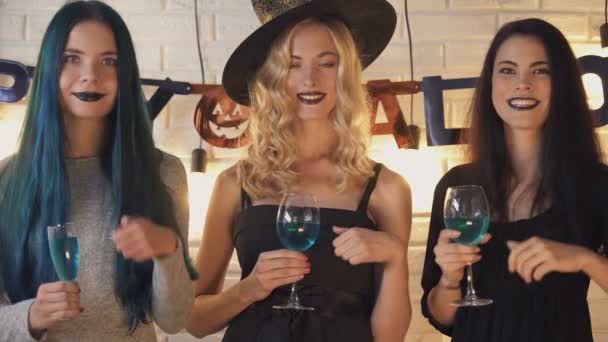 Kolme kaunista naista näyttää peukalot ylös ele, hauskaa Halloween aattona
 - Materiaali, video