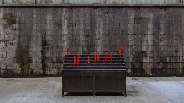 Candele elettroniche sui cavalletti contro il muro di pietra grigia, nel tempio Lingyin, a Hangzhou, Cina
 - Foto, immagini