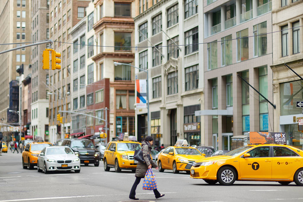 NEW YORK - MARCH 16, 2015: Yellow taxi cabs and people rushing on busy streets of downtown Manhattan - Foto, afbeelding