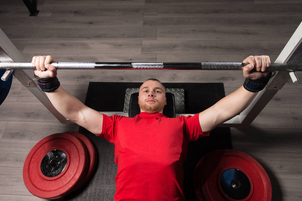 Professional Athlete Is Lying and Is Holding a Very Heavy Barbell - Fotografie, Obrázek