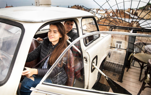 Couple on the roof of a house in an old car. People - Foto, Imagem