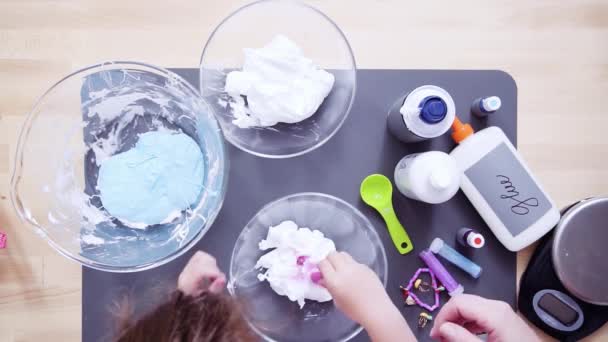 Time lapse. Step by step. Flat lay. Mother and daughter making colorful fluffy slime - Footage, Video