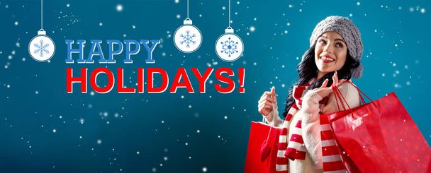 Happy holidays message with woman holding shopping bags - Photo, Image