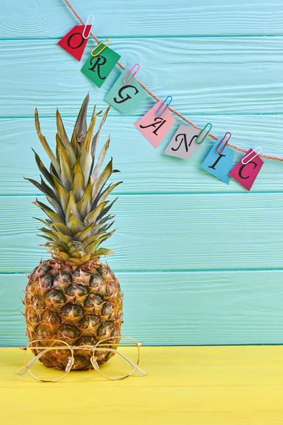 Organic pineapple with eyeglasses on color background. - Valokuva, kuva