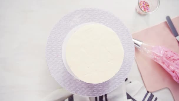 Step by step. Flat lay. Icing tall birthday cake with white buttercream icing - Imágenes, Vídeo