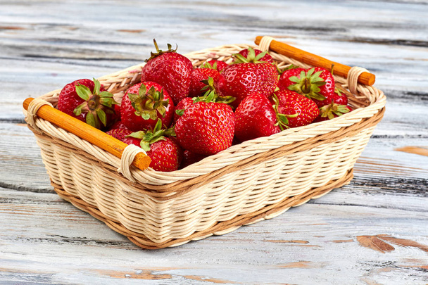 Φρέσκα νόστιμα φράουλες σε ψάθινο καλάθι. - Φωτογραφία, εικόνα