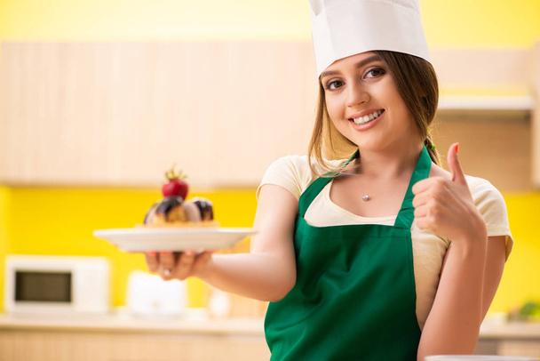 Nuori kokki ruoanlaitto kakkuja keittiössä - Valokuva, kuva