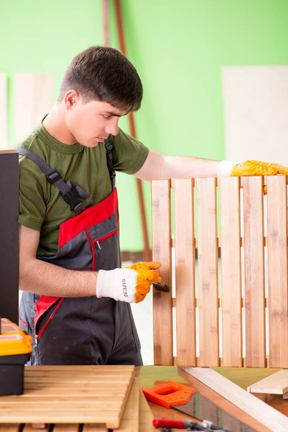 Young man carpenter working in workshop  - Zdjęcie, obraz