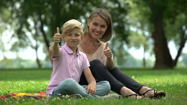 Šťastná žena a chlapec ukazuje palec nahoru, ad sociální podpory pro svobodné matky - Záběry, video