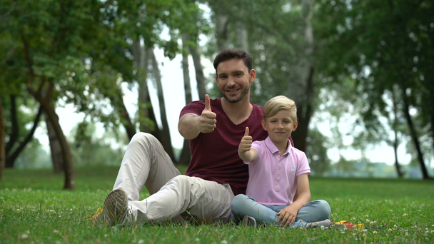 Muž a chlapec ukazují palce, sociální podporu pro neúplné rodiny, pohodu - Záběry, video