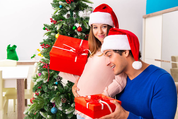 Raskaana oleva vaimo celevrating joulu miehensä kanssa - Valokuva, kuva