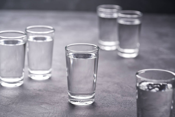 Ruská vodka záběry na černém stole, selektivní fokus. Vodka v štamprle na černém pozadí - Fotografie, Obrázek