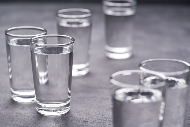 Vodka russe sur table noire, mise au point sélective.Vodka dans des verres de vue sur fond noir
 - Photo, image
