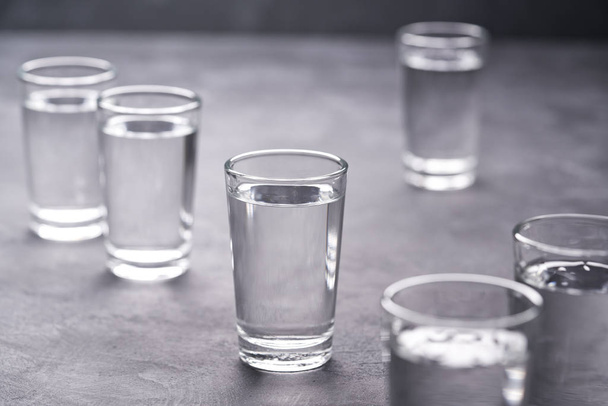 Vodka ruso sobre mesa negra, enfoque selectivo.Vodka en vasos de chupito sobre fondo negro
 - Foto, imagen