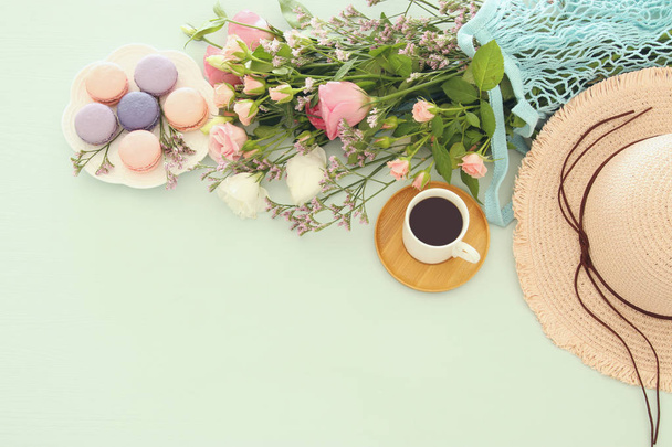 plate of macaroons over wooden table cofee and flowers - Foto, afbeelding