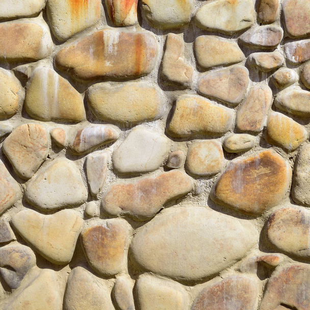 A fragment of a wall from a chipped stone in a background photo. - Foto, afbeelding