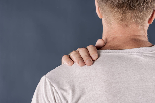 Man holding his sore shoulder trying to relieve pain - Foto, Imagem