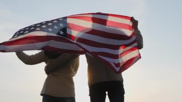 Rückseite patriotische Familie mit einer großen Flagge Amerikas - Filmmaterial, Video