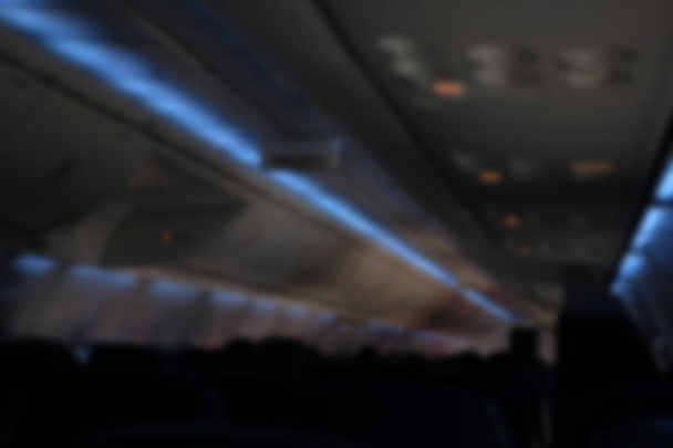 passenger sit on seat in airplane. aeroplane interior. blurry defocused background - Photo, Image
