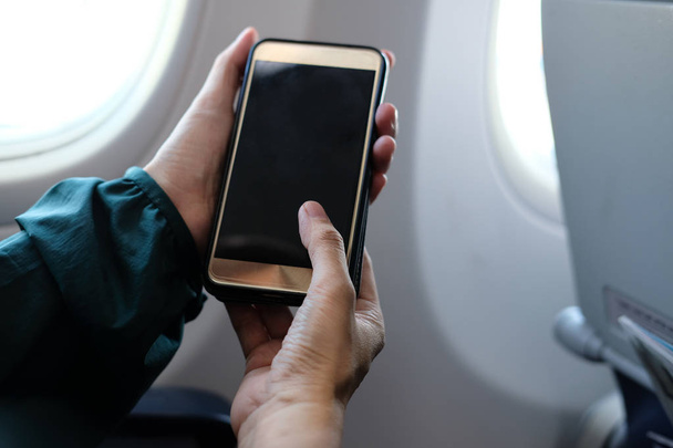 uçağın içinde Smartphone kullanarak kadın gezgin. uçaklarda cep telefonu tutan yolcu. seyahat ve bağlantı - Fotoğraf, Görsel