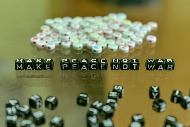 平和ない戦争ガラス背景の上に白いアルファベット ビーズ アクリル ブラック キューブと書かれて - 写真・画像