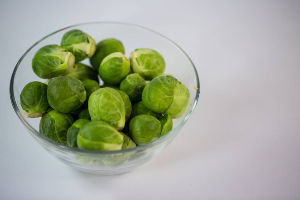 Brussels sprouts in a glass bowl, white background - Photo, Image