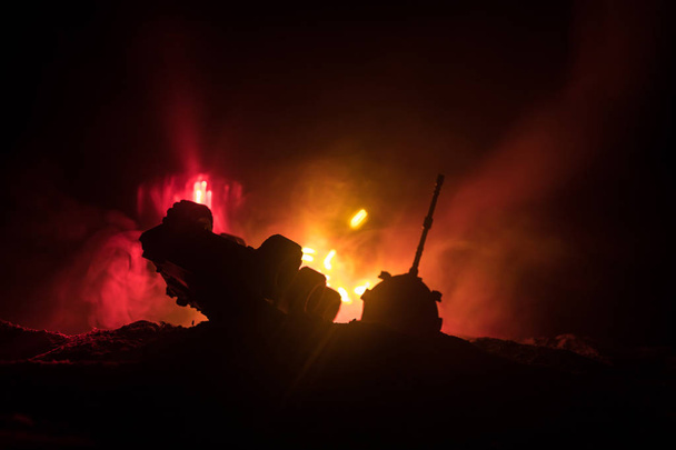 War Concept. Armored Tank Silhouette Below foggy fire sky at night. Attack scene. Toy decoration. Selective focus - Valokuva, kuva