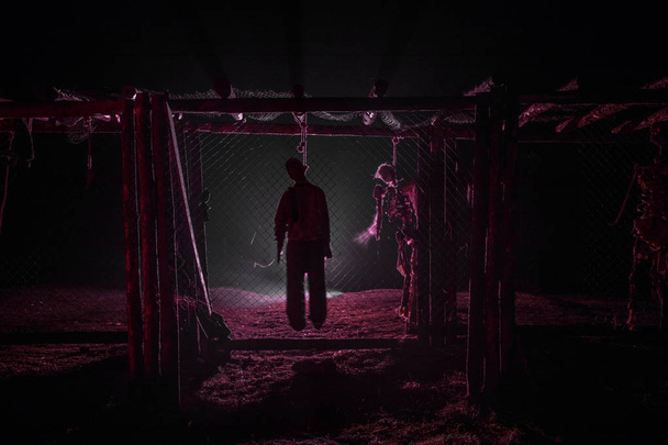 Horror-Ansicht Silhouette des erhängten Mannes auf einem Baugerüst in der Nacht mit Nebel und getöntem Licht auf dem Hintergrund. Hinrichtung (oder Selbstmord). Horror-Halloween-Konzept. - Foto, Bild