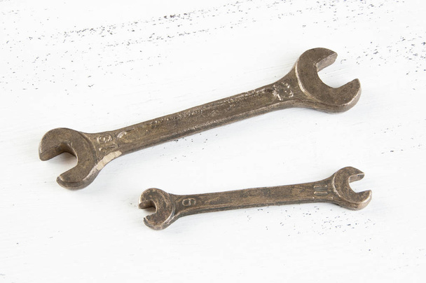 Vintage bronzových klíčů na omšelé bílé dřevěné pozadí. Kopírovat prostor pro text. - Fotografie, Obrázek
