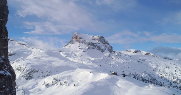 Aérea hacia adelante a través de majestuosas monturas rocosas Cinque Torri que muestran pistas de esquí. Día soleado con cielo nublado.Invierno Dolomitas Alpes italianos montañas naturaleza al aire libre establecier.4k vuelo drone
 - Metraje, vídeo