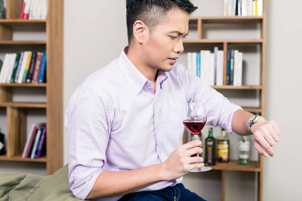 Άνθρωπος που κρατά ποτήρι κρασί κοιτάζοντας το χρόνο στο Ρολόι χεριού - Φωτογραφία, εικόνα