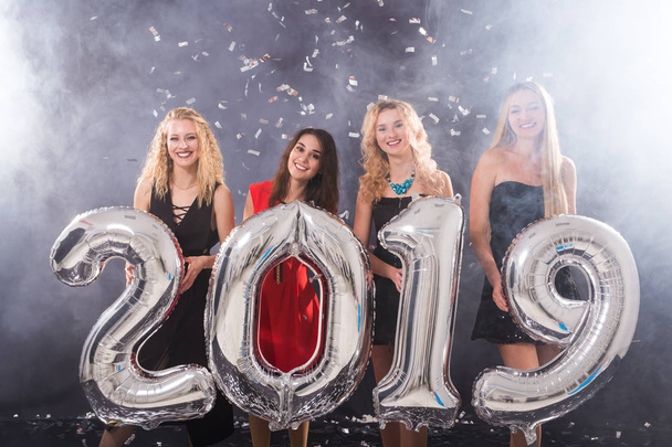 Das neue Jahr 2019 kommt. Gruppe fröhlicher junger Frauen mit silberfarbenen Nummern auf der Party. - Foto, Bild
