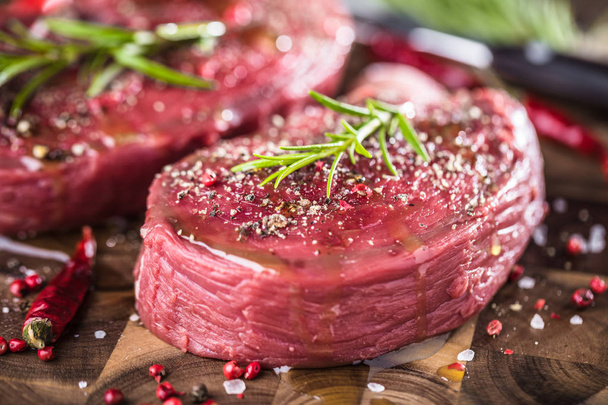 Raw beef steak on a dark wooden table. - Fotografie, Obrázek